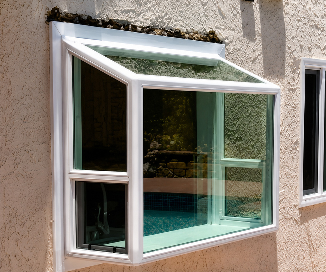 Garden window installed above a kitchen sink with plants and natural light